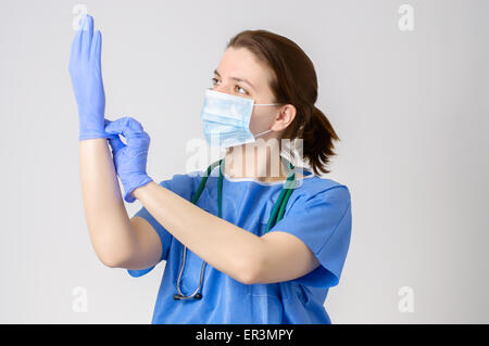 Ärztin, blaue OP-Handschuhe anziehen Stockfoto