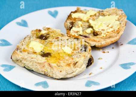 Gebutterte Hot Cross Buns oder Obst Brötchen auf Platte Stockfoto