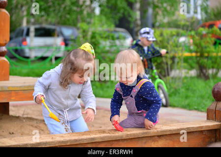 Zwei kleine Schwestern spielen im Sandkasten Stockfoto