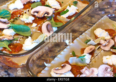 Vorbereitung ungekochte Lasagne Schichten zu Gemüse Lasagne mit Champignons und Artischockenherzen Stockfoto