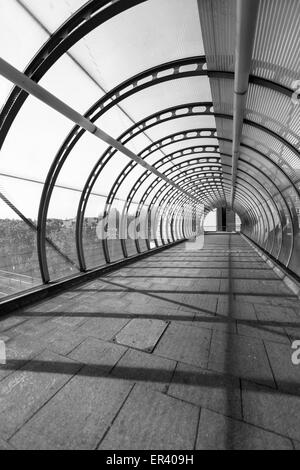 Pappel DLR Station hochrangige Gehweg, blieb ein Kabel Fußgängerbrücke mit gewölbten Glasdach in den Docklands von London, UK Stockfoto