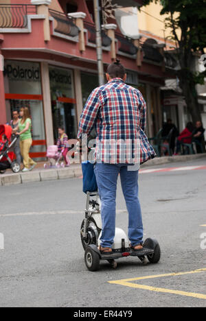 Mann auf Elektro-Roller auf der Straße fahren Stockfoto