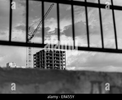 Neubau Hochhaus Wohnung gegen ein bewölkter Himmel mit Baukran Stockfoto