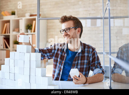 Glücklich Kaufmann Bau Papier Pyramide am Arbeitsplatz Stockfoto