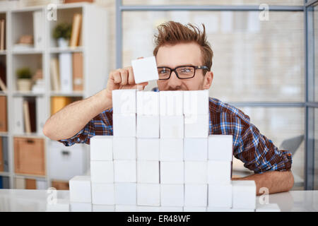 Kreative Unternehmer setzen Cube auf Papier-Pyramide Stockfoto