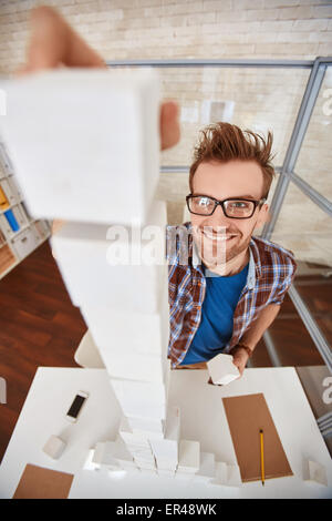 Junge Designer oder Architekten setzen Cube Spitze hohe Pyramide Stockfoto