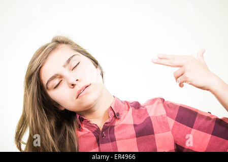 Junge Teenager vorgibt, dass sie sich in den Kopf mit der Hand dreht. Stockfoto