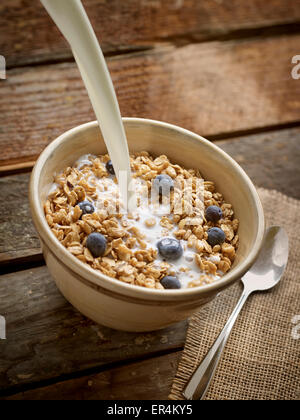 Schüssel Müsli Müsli mit Milch gießen Stockfoto