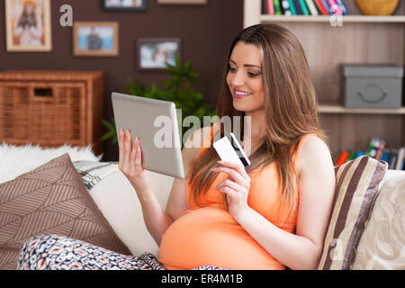 Schwangere Frau tun, online einkaufen und bezahlen per Kreditkarte. Debica, Polen Stockfoto