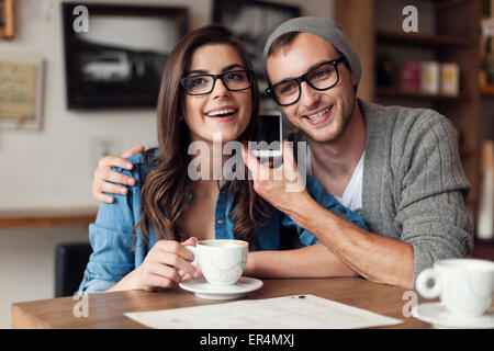 Glückliches junges Paar hören Stimme von Handy. Krakau, Polen Stockfoto