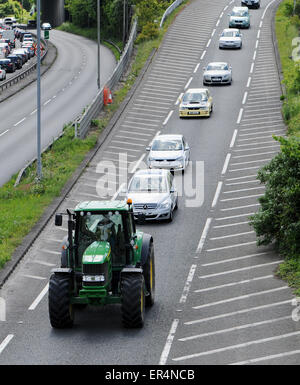 Langsam bewegende Ackerschlepper verursacht Staus mit Schweif hinter Autos hinter unterwegs Stockfoto