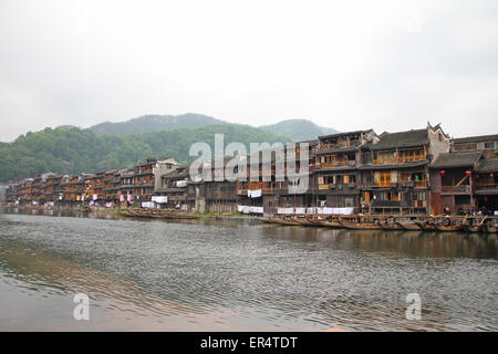 FENGHUANG - Mai 12: Holzboot und Holzhäuser am Tuojiang Fluss in Fenghuang alte Stadt am 12. Mai 2011 in Fenghuang, Kinn Stockfoto