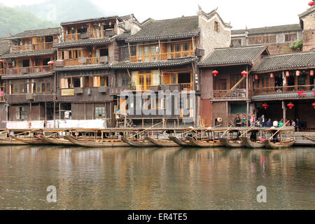 FENGHUANG - Mai 12: Holzboot und Holzhäuser am Tuojiang Fluss in Fenghuang alte Stadt am 12. Mai 2011 in Fenghuang, Kinn Stockfoto