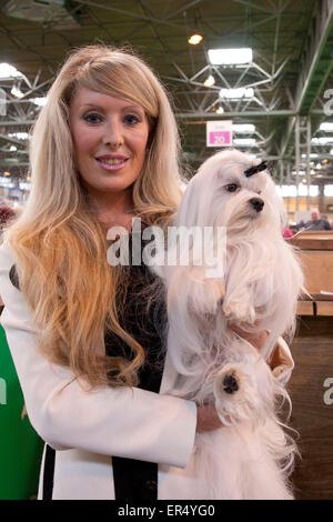 Attraktive blonde junge Frau mit Hund, die sieht aus wie ihr.  Crufts 2014 im NEC in Birmingham, Großbritannien. 8. März 2014 Stockfoto