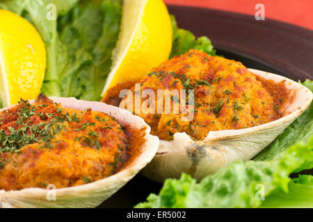 Gefüllte erfahrene Muscheln mit Romaine Kopfsalat und Zitrone Keile auf einem rustikalen Teller garniert Stockfoto