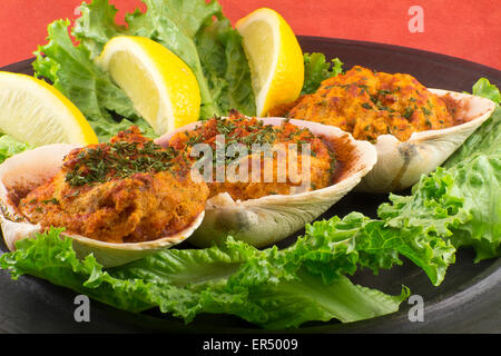 Gefüllte erfahrene Muscheln mit Romaine Kopfsalat und Zitrone Keile auf einem rustikalen Teller garniert Stockfoto