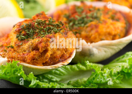 Gefüllte erfahrene Muscheln mit Romaine Kopfsalat und Zitrone Keile auf einem rustikalen Teller garniert Stockfoto