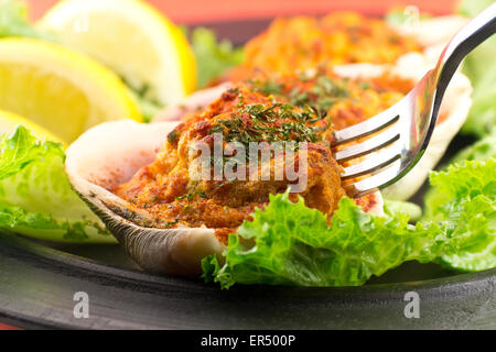 Gefüllte erfahrene Muscheln mit Romaine Kopfsalat und Zitrone Keile auf einem rustikalen Teller garniert Stockfoto