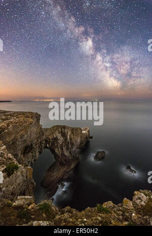 Grüne Brücke von Wales in Pembrokeshire, einem natürlichen See-Bogen; in der Nacht mit dem Spiralarm unserer Milchstraße Galaxie eingefangen Stockfoto