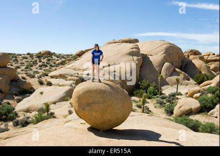 Landschaft der Mojave-Wüste mit Mädchen steht auf große Runde Felsbrocken, Southern California, USA. Stockfoto