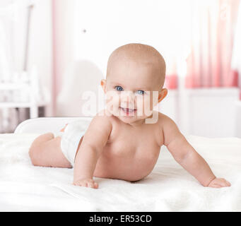 gesundes, glückliches Baby auf Bett liegend Stockfoto