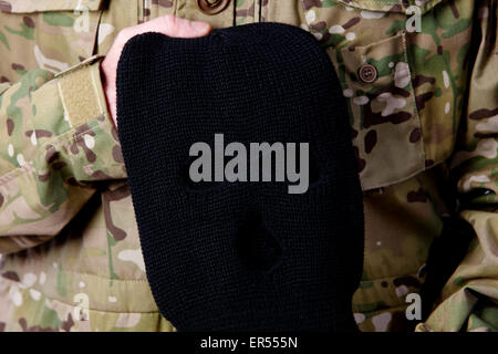 Mann in Kampfuniform mit schwarzer STURMHAUBE balaclava Stockfoto