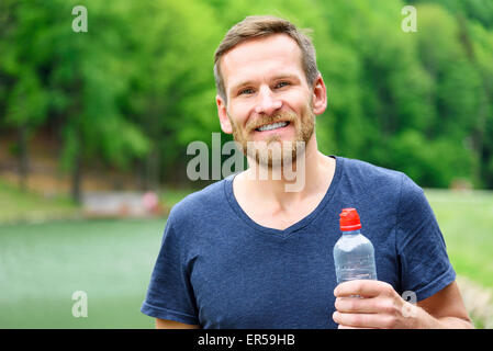 Sportler mit einer Flasche Wasser. Stockfoto