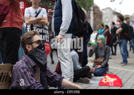 London, UK. 27. Mai 2015. Ein Demonstrator sitzt vor Downing Street, London und an einem Abend des Protests gegen öffentliche Ausgabenkürzungen von der britischen Konservativen Partei in den Jahren eingeführt, da die Partei, auch bekannt als die Tories im Jahr 2010 an die Macht kam. Am Abend Proteste fanden statt, am Tag der Parlamentseröffnung, mit Ausgabenkürzungen setzt sich fort – und viele fürchten, zu vertiefen – folgt die konservativen Überraschung Mehrheit bei den letzten Parlamentswahlen Großbritanniens gewinnen. Bildnachweis: David Cliff/Alamy Live-Nachrichten Stockfoto