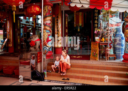 Mutter und Sohn sitzen auf den Stufen des Tempels, Chiantown, Singapur Stockfoto