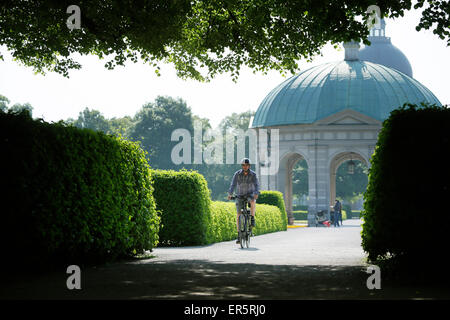 Mann reitet ein e-Bike durch Hofgarten, München, Oberbayern, Deutschland Stockfoto