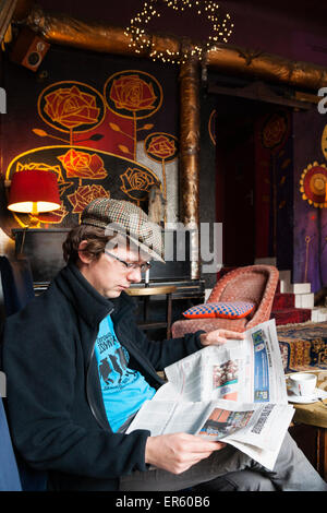 Polnische Mann liest Zeitung im Inneren eine böhmische Bar, W Oparach Absurdu Pub, Stadtteil Praga, Warschau, Polen, Europa Stockfoto