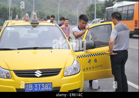 Chongqing, China. 28. Mai 2015. Ein Mann fügt Sonne blockiert Film zu einem Taxi in Chongqing, Südwest-China, 28. Mai 2015. Mehr als 14.000 Taxis werden am Ende des Mai, Fahrer Sorge auf grellen Sonnenschein des Sommers zu lösen mit Sun-Blocker Film eingefügt. Bildnachweis: Tang Yi/Xinhua/Alamy Live-Nachrichten Stockfoto