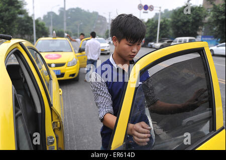 Chongqing, China. 28. Mai 2015. Ein Mann fügt Sonne blockiert Film zu einem Taxi in Chongqing, Südwest-China, 28. Mai 2015. Mehr als 14.000 Taxis werden am Ende des Mai, Fahrer Sorge auf grellen Sonnenschein des Sommers zu lösen mit Sun-Blocker Film eingefügt. Bildnachweis: Tang Yi/Xinhua/Alamy Live-Nachrichten Stockfoto