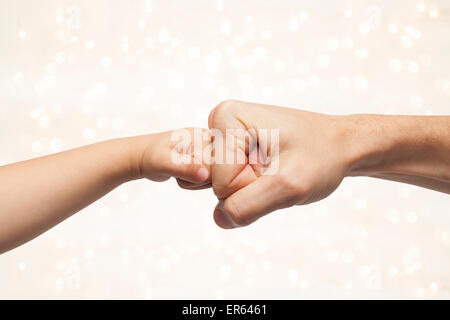 Vater und Sohn Stanzen Fäuste für Abkommen auf schönen Weihnachten Lichter Hintergrund. Stockfoto