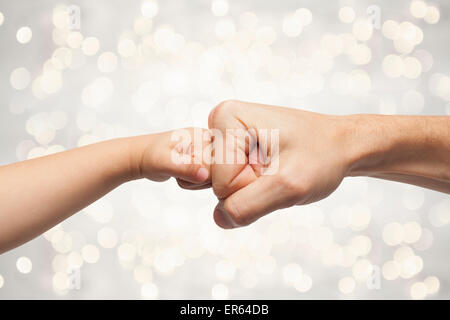 Vater und Sohn Stanzen Fäuste für Abkommen auf schönen Weihnachten Lichter Hintergrund. Stockfoto