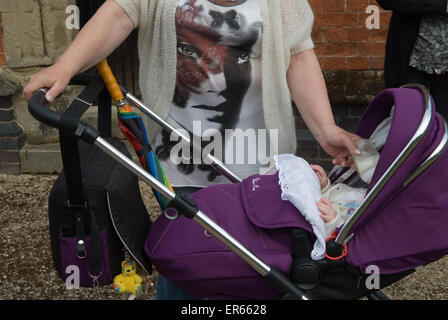 Mit der Flasche füttern Baby in einem Kinderwagen. Bedworth Warwickshire UK HOMER SYKES Stockfoto
