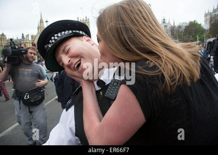 London, UK. Mittwoch, 27. Mai 2015. Junge Demonstrant spielt sanft mit der Polizei, ein Polizist zu küssen, wie Studenten demonstrieren Stockfoto