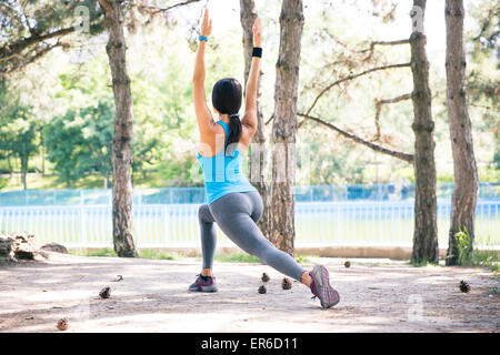 Zurück Blick Porträt einer sportlichen Frau stretching im Freien im park Stockfoto