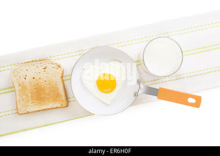 Spiegelei in Herzform auf Pfanne mit Toast und Milch, Ansicht von oben. Ich liebe das Frühstück. Frische, moderne Bildsprache. Kochkunst. Stockfoto