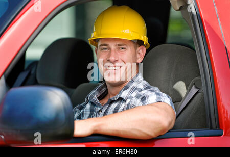 Schönen muskulösen jungen Bauarbeiter lächelnd In Fahrzeug Stockfoto