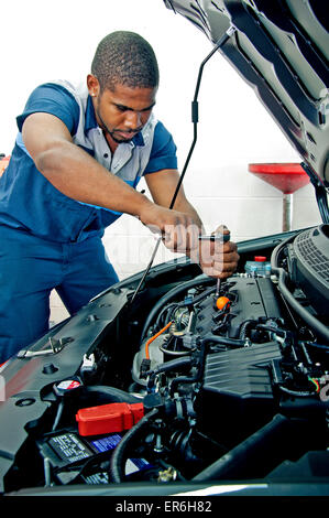 Gut aussehende Mechaniker arbeiten auf Auto-Motor unter der Haube Stockfoto