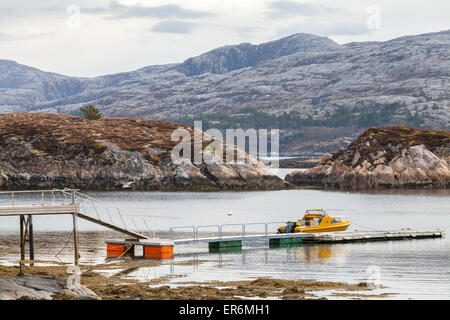 Ländlichen norwegischen Küstenlandschaft. Kleines Motorboot steht in der Nähe von schwimmenden Steg festgemacht Stockfoto