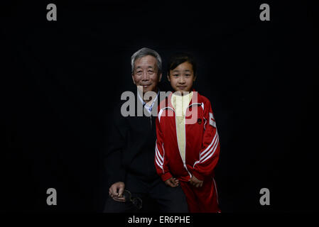 Jiaxing, Zhejiang, China 16. Mai 2015 Guisheng Guo, 68 und seine Enkelin Yuanyuan Guo, 9, posieren für Fotografie. Yuanyuan der Mutter, das einzige Kind von Guisheng Guo, starb im Jahr 2011. Wegen Tod der Tochter starb Guo Frau auch zwei Jahre später. Gibt es etwa mehr als 1 Million Familien verloren ihr einziges Kind in China. China Medienberichten zufolge gibt es 190,000015 Millionen Jahr-alte Menschen, die nur ein Kind in ihre Familie und es gibt mehr als 2 Millionen alte Menschen, die ihr einziges Kind verloren.  Es erhöht 78.000 Familien pro Jahr. Mehr als 2 Millionen Senioren verloren ihre einzige c Stockfoto