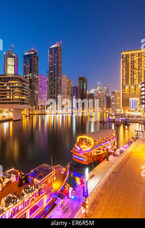 Skyline von Dubai Marina und touristische Boote bei Nacht Dubai Stadt Vereinigte Arabische Emirate VAE Naher Osten Stockfoto