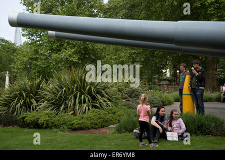 Lambeth. Imperial War Museum. Junge Menschen essen Eis neben zwei 15' Marinegewehren außerhalb des Museums Stockfoto