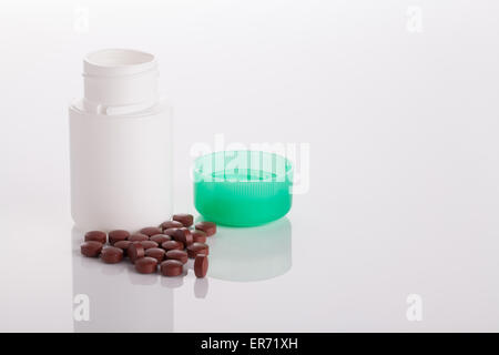 Tabletten und ein Glas auf eine glänzende Oberfläche Stockfoto