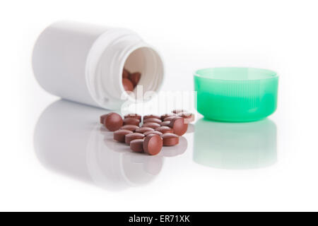 Tabletten und ein Glas auf eine glänzende Oberfläche Stockfoto