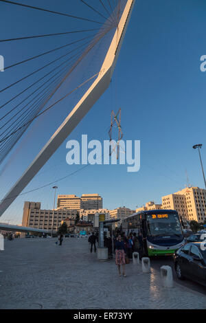 Jerusalem, Israel. Menschen in der Nähe eine Bushaltestelle und ein großer Davidstern hängen von der Akkorde-Brücke am Eingang der Stadt. Stockfoto