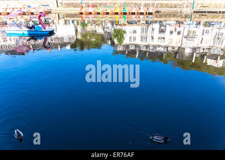 Bouillon (Belgien). Enten schwimmen und schwanenförmigen Boote auf dem Fluss; die Stadt im Hintergrund. Blauer Himmel und Reflexionen. Stockfoto