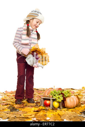 Mädchen mit Obst und Gemüse auf Herbstlaub auf weiß Stockfoto